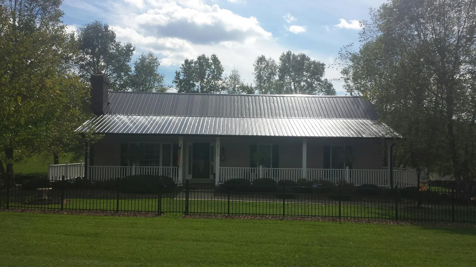 Gray metal roof on a brick ranch with a full width front porch — Gutter Guard Installation work by our crew in Darlington